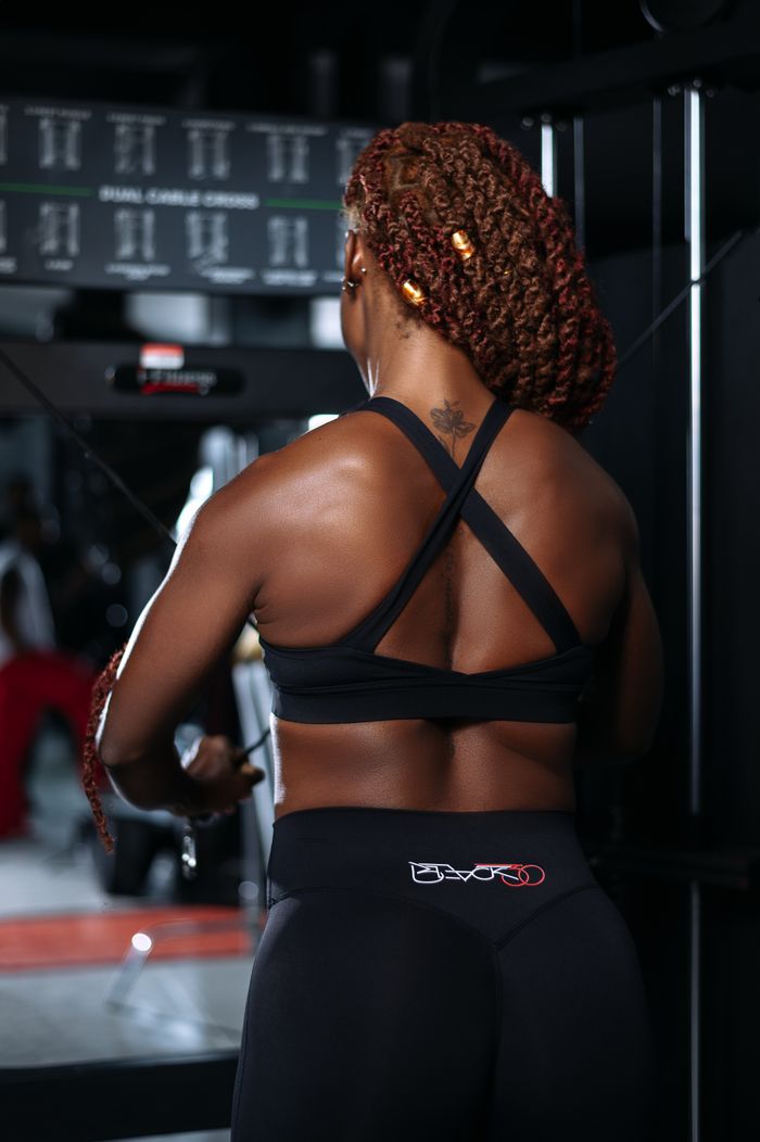Fit woman lifting weights at the gym, focusing on workout.